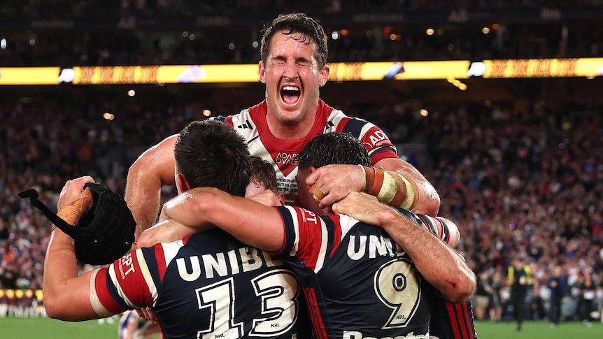 Nat Butcher jumps on Roosters teammates after winning the NRL grand final.